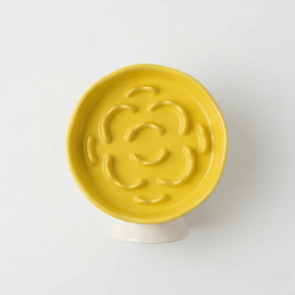 Ceramic slow feeder bowl on a raised stand that helps slow down fast-eating pets