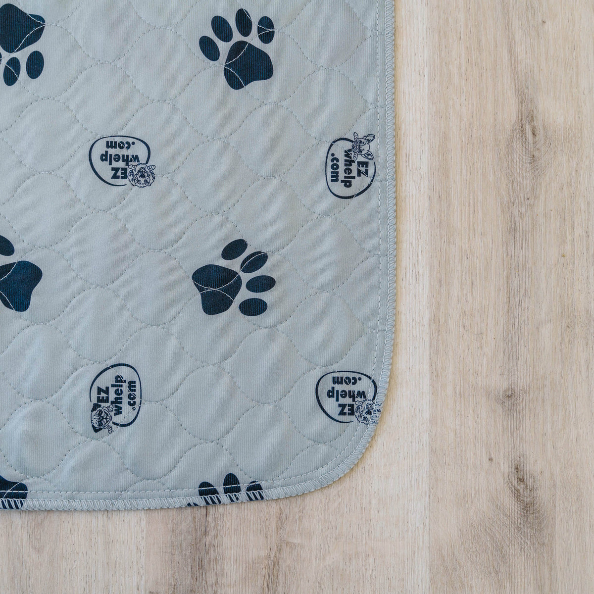 Gray EZwhelp paw print pad quilted to an absorbent soaker, with serged safety-stitched edges