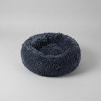 Blue round plush donut pet bed with a raised edge that supports head and neck
