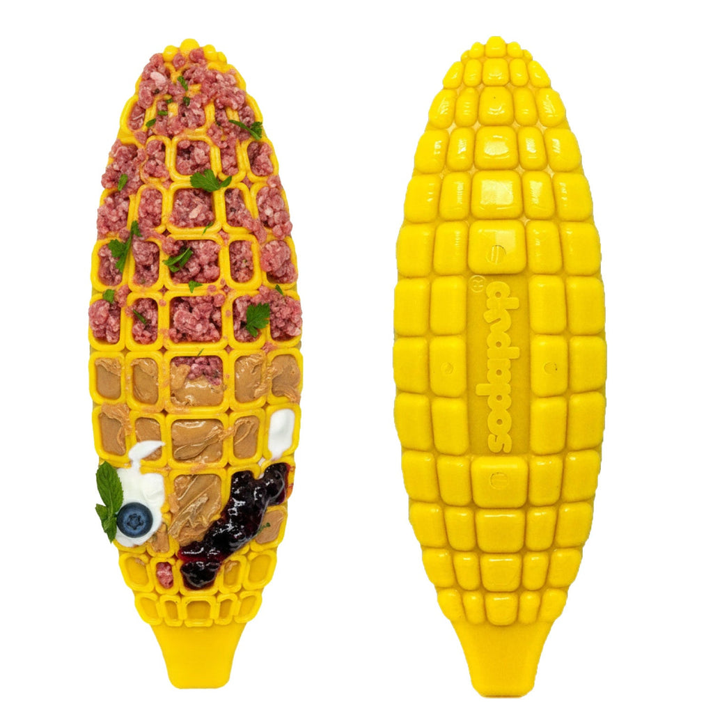 Front and back of the yellow SodaPup nylon Corn on the Cob chew toy, shown with food